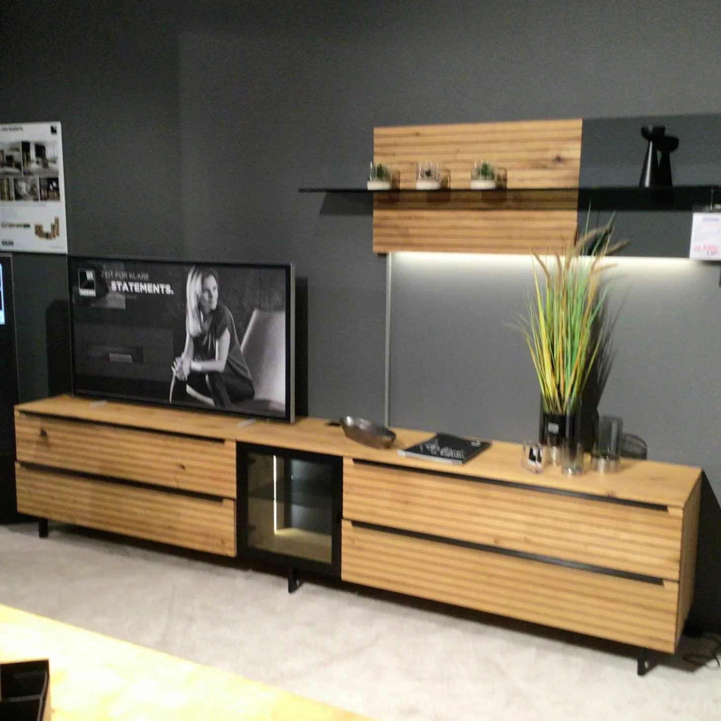 Wohnwand WK490 Baristo V18003 Asteiche Natur Front Mitte aus Farbglas Anthrazit Satiniert